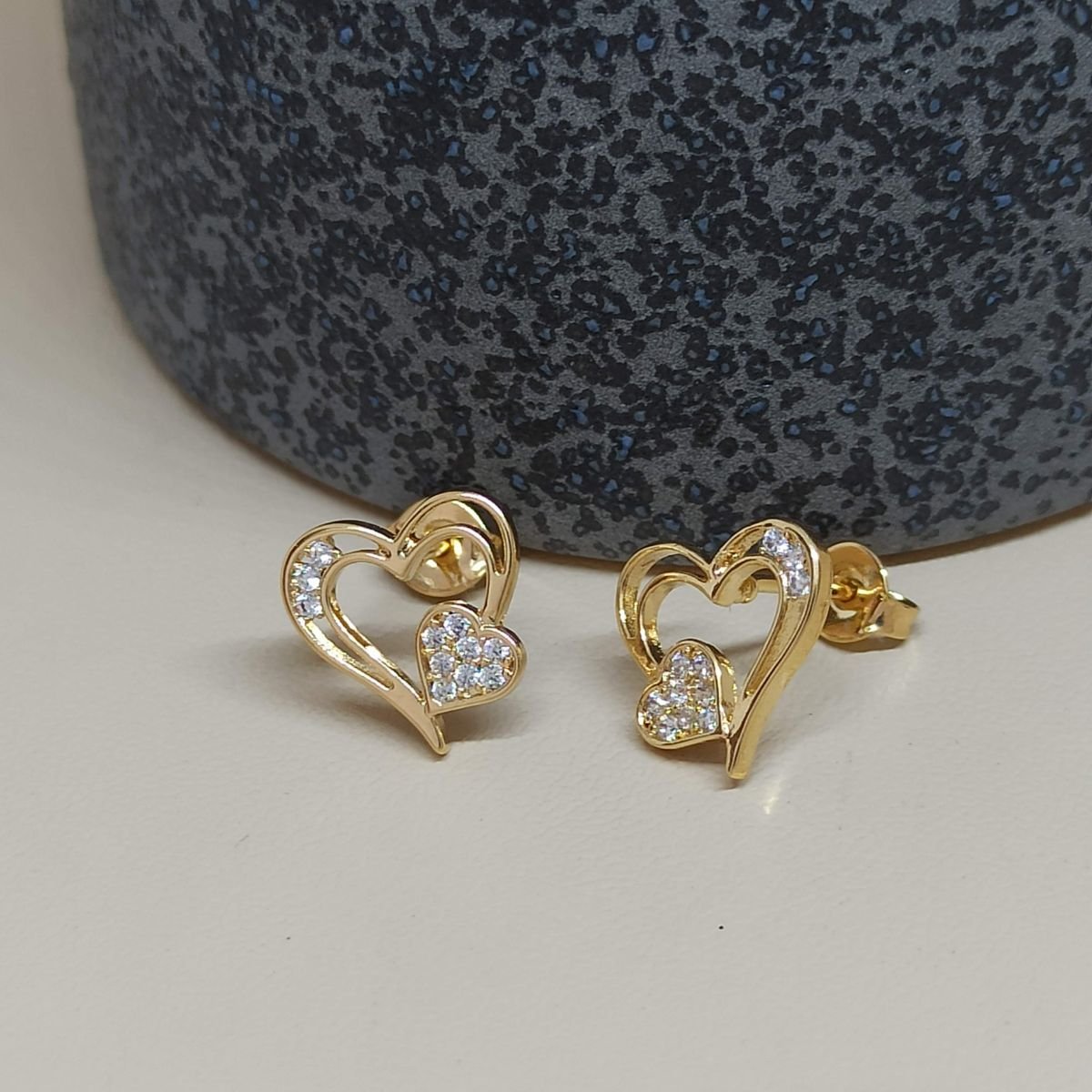 Brinco folheado a ouro de corações vazados cravejados
