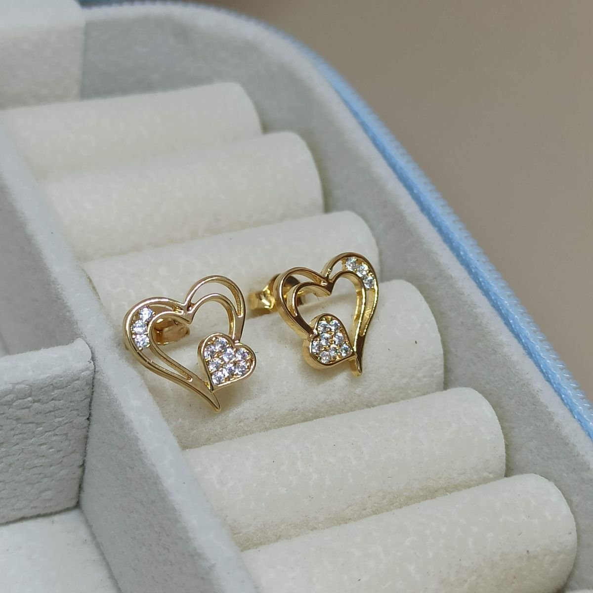 Brinco folheado a ouro de corações vazados cravejados